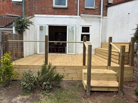Raised timber deck with wire balustrade, steps and built-in bench storage