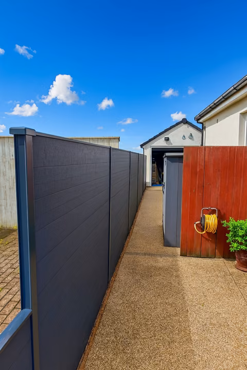 Anthracite Prima composite fence boards stacked within DuraPost supports in Downend