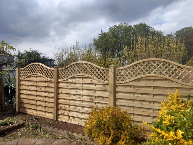 Curved Oasis fence panels with diamond trellis tops installed between 4x4 timber posts