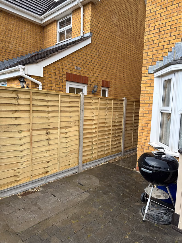 Overlap timber fence panels with concrete posts and 6-inch gravel boards