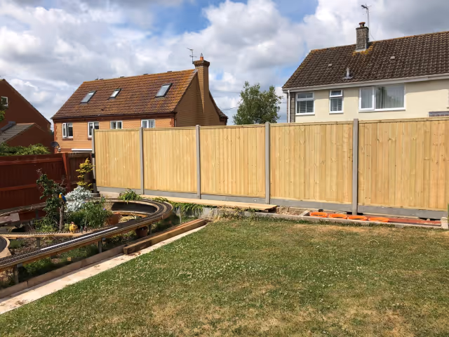 Tongue-and-groove timber fence panels fitted with concrete posts and gravel boards