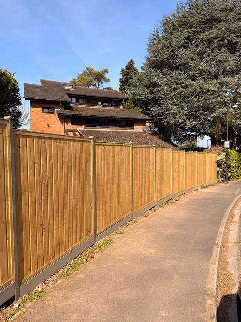 Completed tongue-and-groove timber fencing installed between olive green DuraPost steel posts