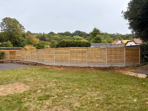 Long level run of contemporary timber fencing with concrete posts and gravel boards in Lawrence Weston