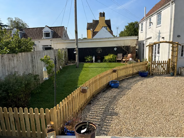 Curved timber picket fence with matching gate and garden arch