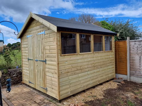 Large timber workshop shed with double doors and a long bank of windows installed in a Bristol garden