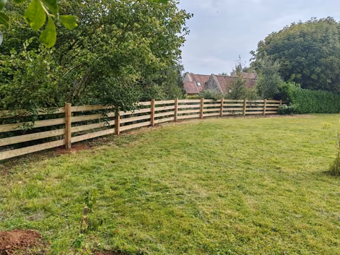 Second view of the dog-safe fence showing the horizontal rails and timber posts